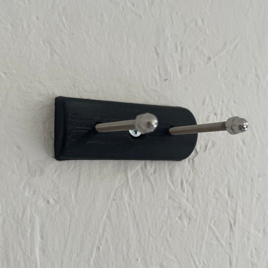 Black key holder with two keys on a white wall