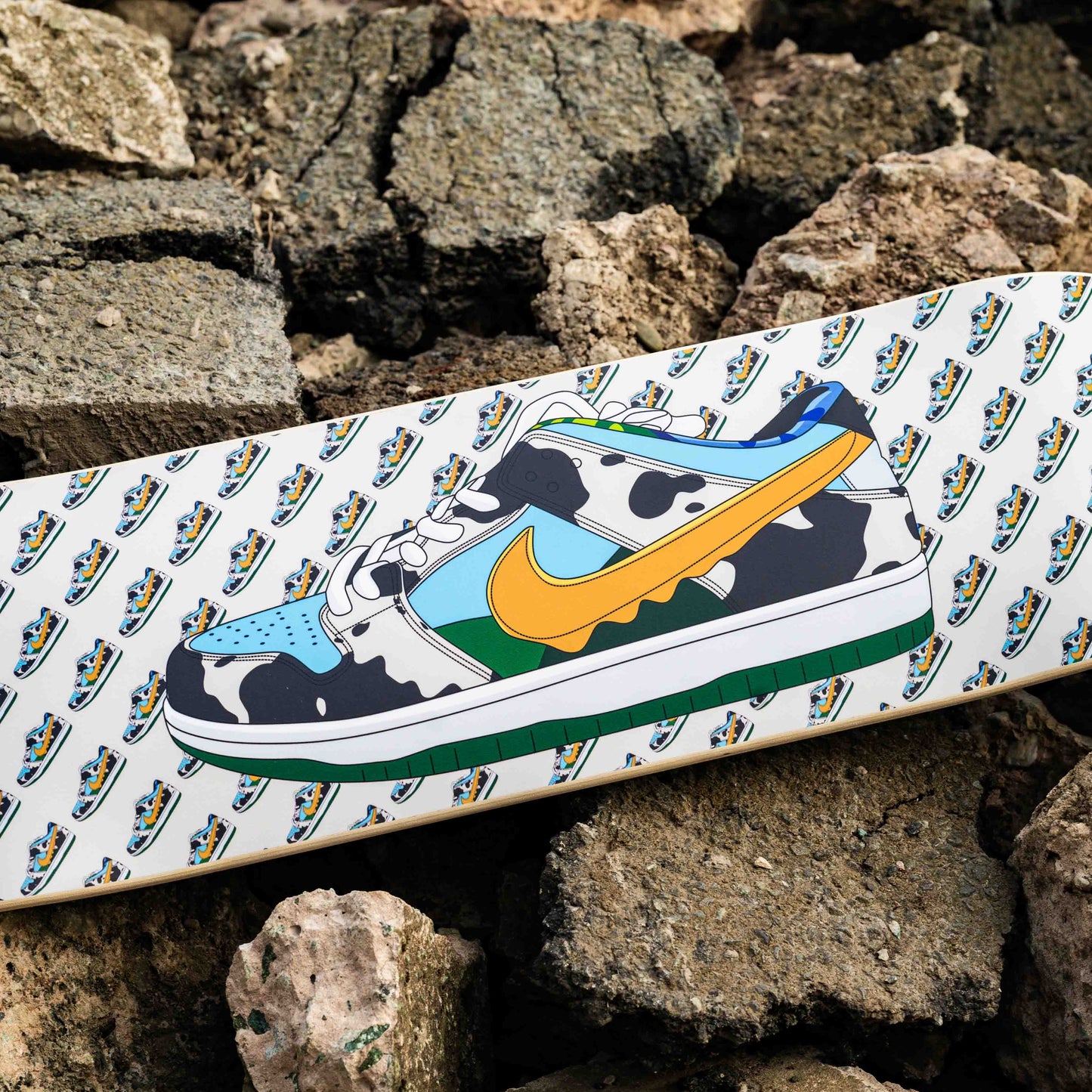 Skateboard with cow print design on a pile of rocks