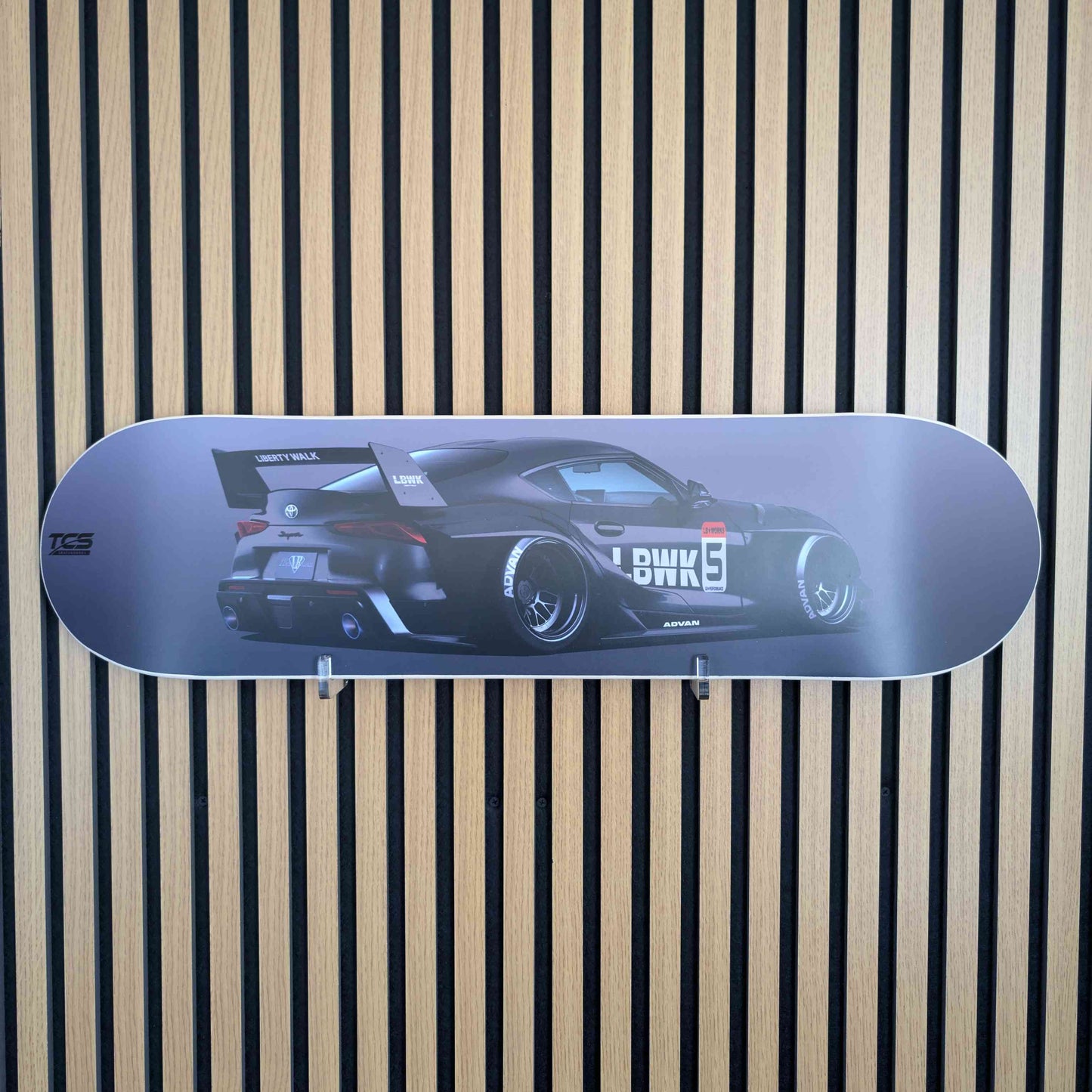Skateboard deck with car design on a striped background