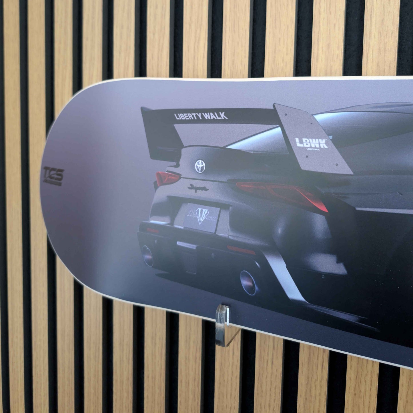 Skateboard deck with car design and 'Liberty Walk' branding against a striped background
