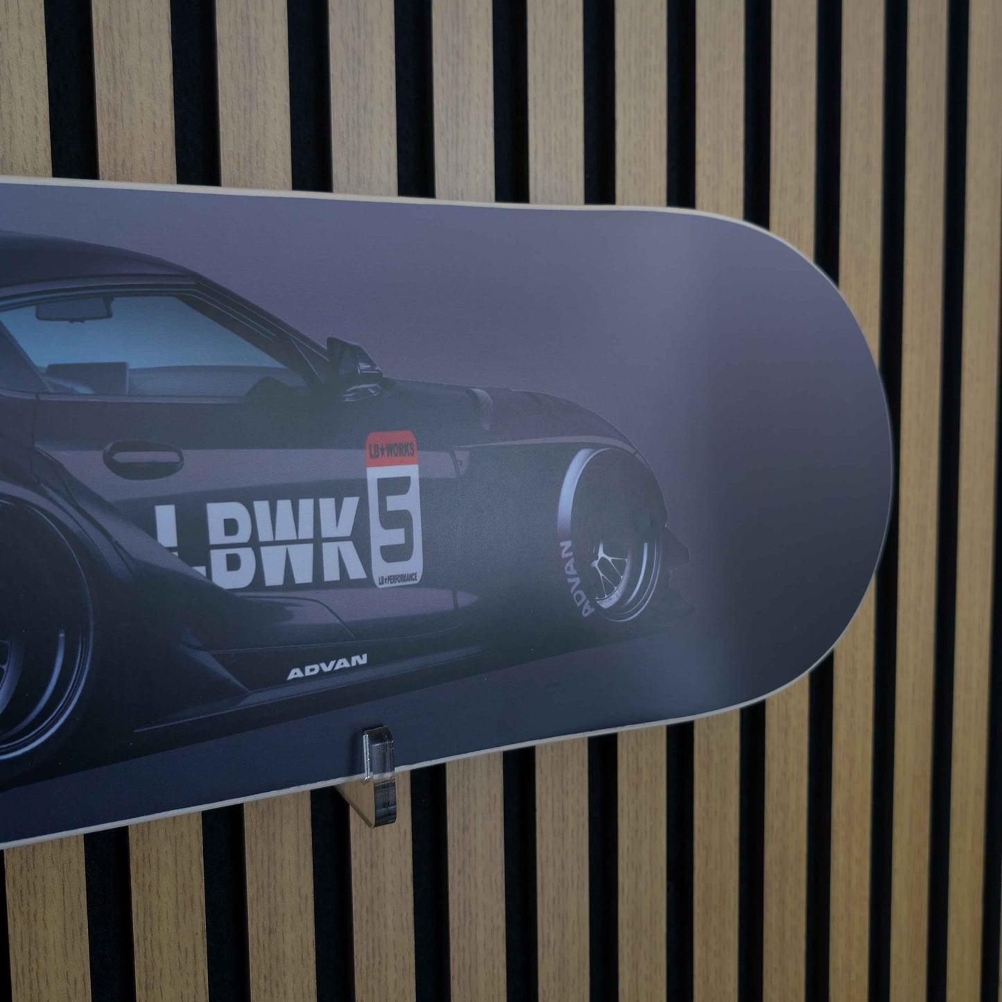 Skateboard deck with a car graphic and 'LBWK' branding on a striped background