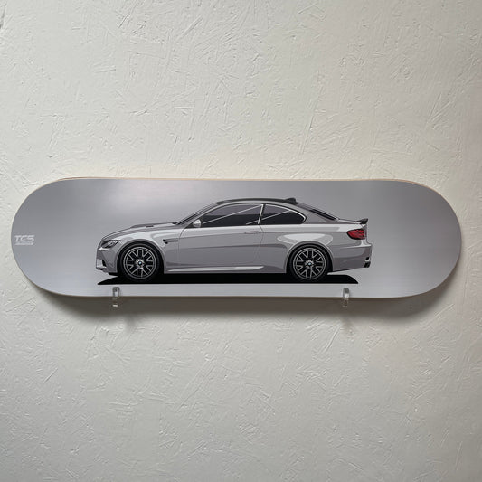 Skateboard deck with a car design on a plain wall