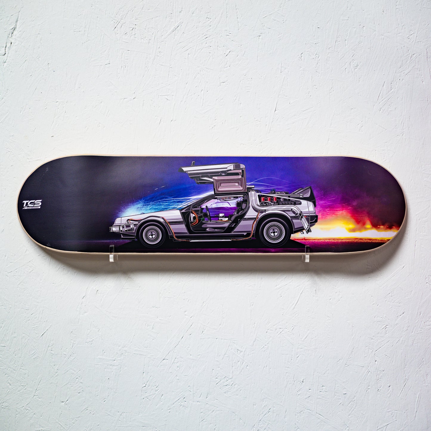 Skateboard deck with a futuristic car design on a white wall