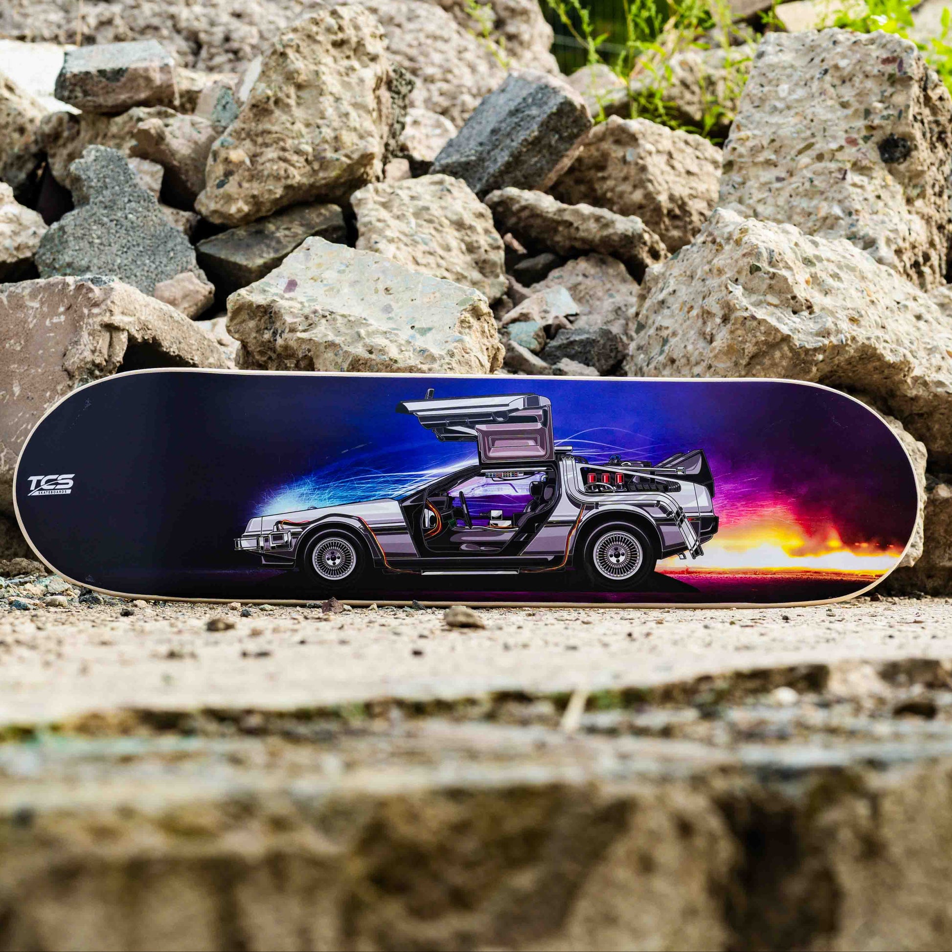 Skateboard with a futuristic vehicle design on a rocky surface