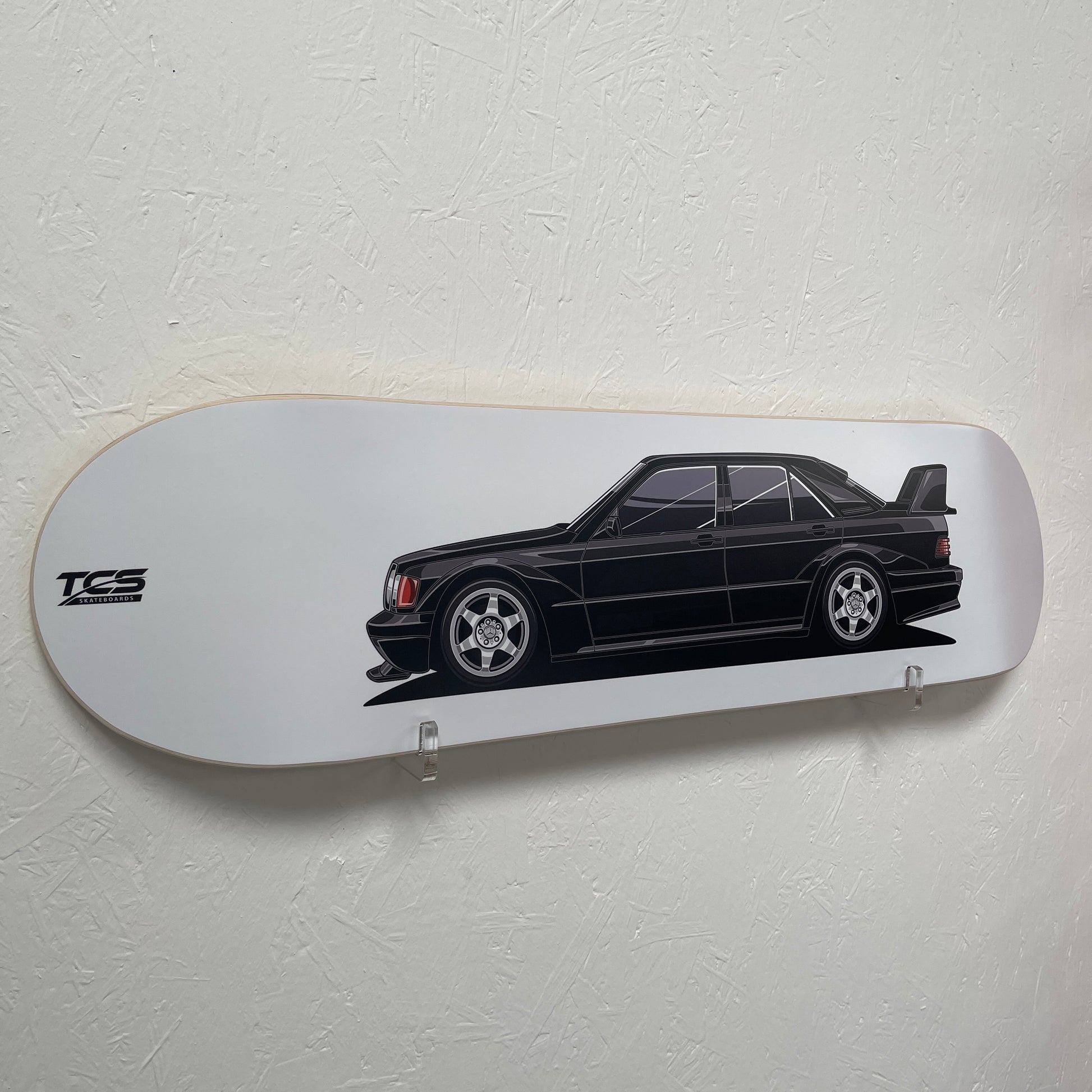 Skateboard deck with a black car illustration and TCS logo on a white background
