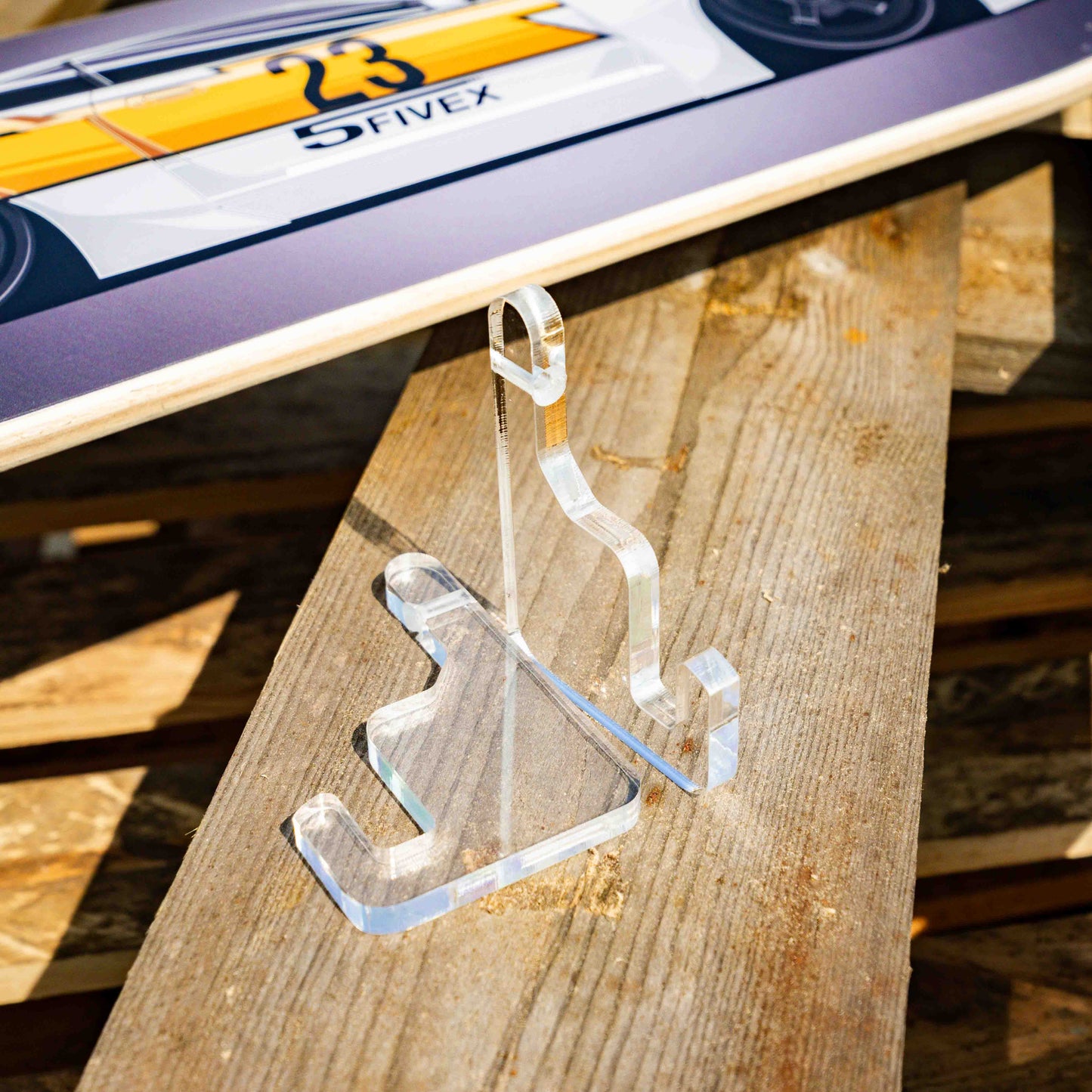 Clear acrylic hanger on a wooden surface with a blurred background
