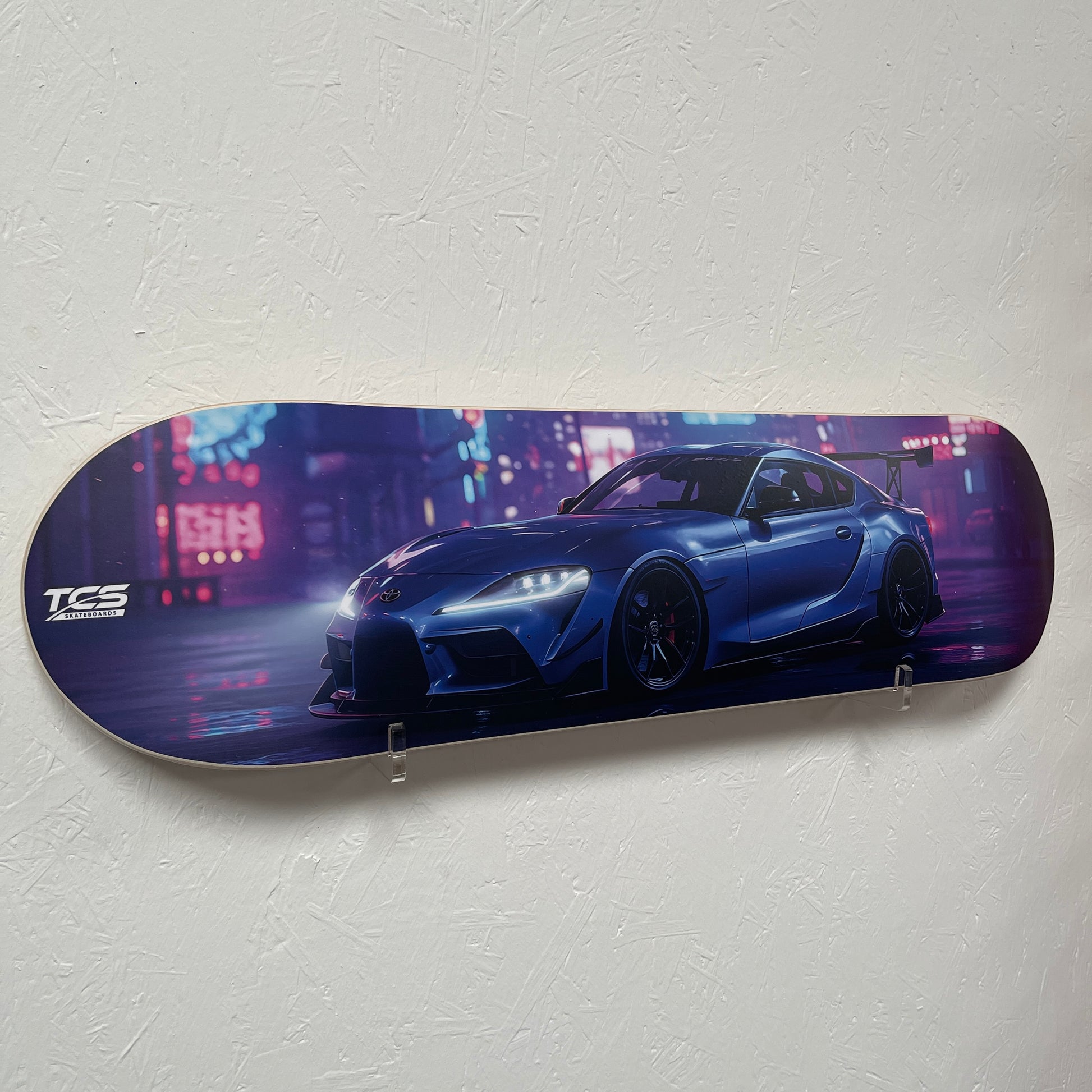 Skateboard deck with a blue car design on a gray background