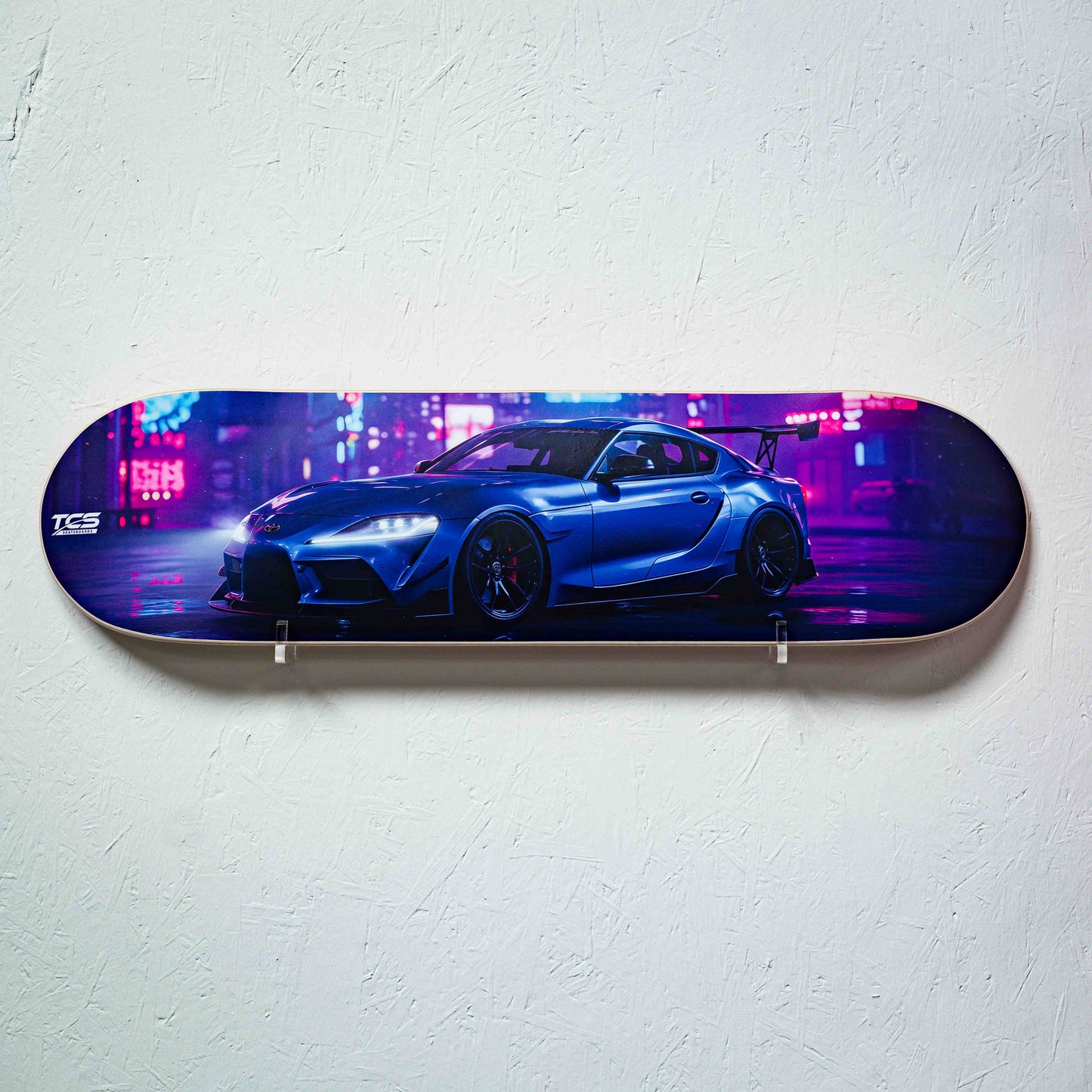 Skateboard deck with a blue car design on a white wall