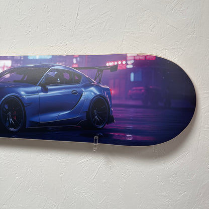 Blue sports car on a skateboard deck against a white wall