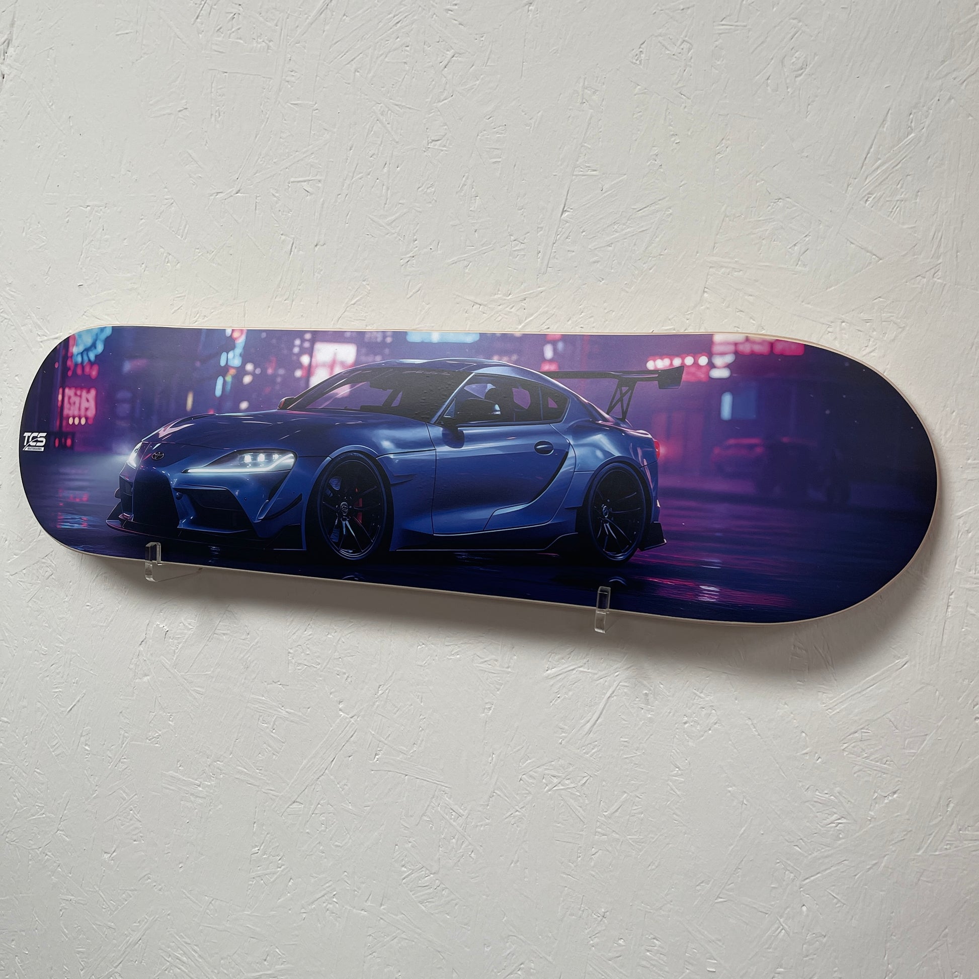 Skateboard deck with a blue car design on a white wall