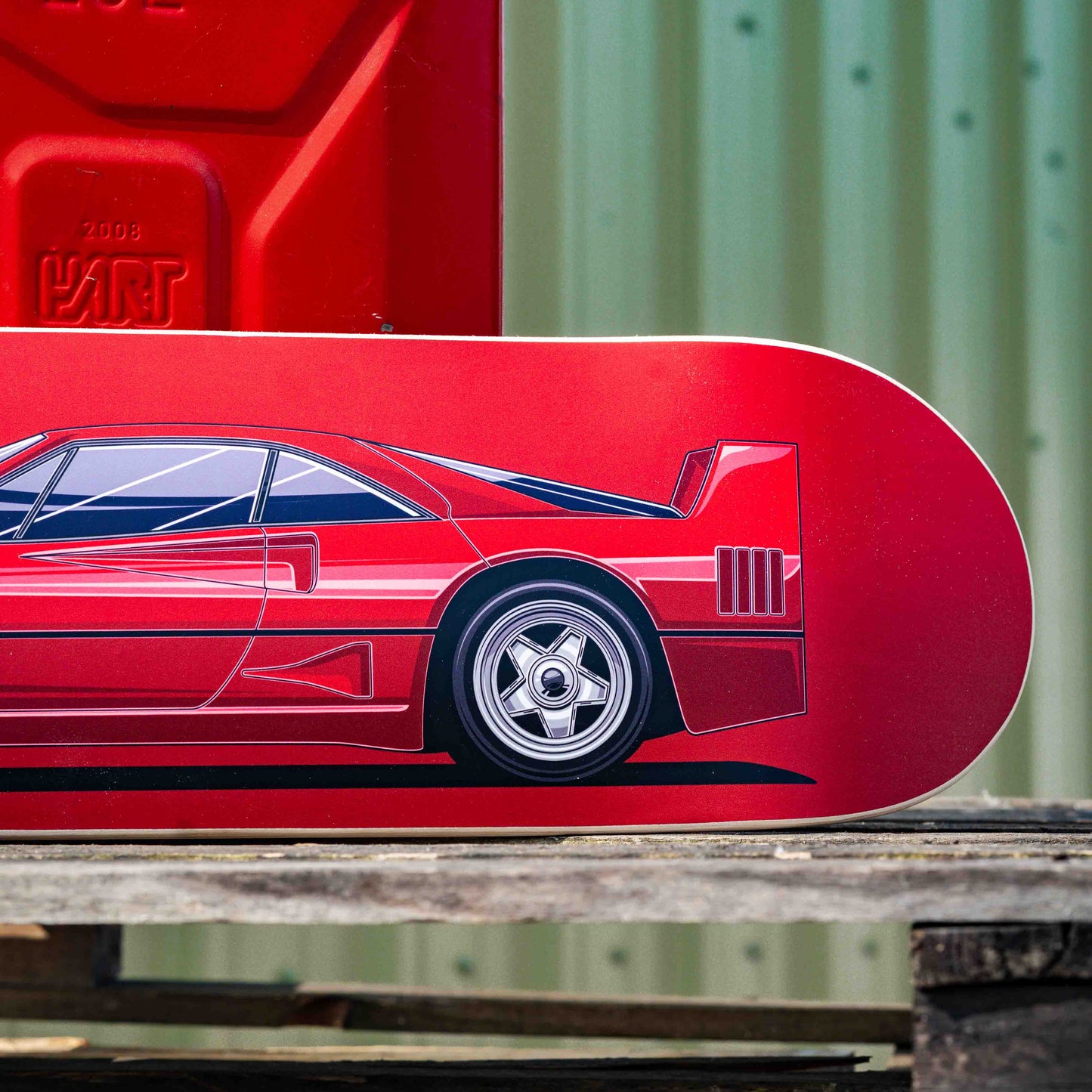 Red skateboard deck with car design on a wooden surface