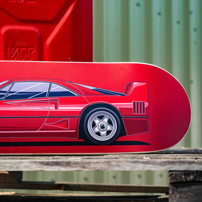Red skateboard deck with car design on a wooden surface