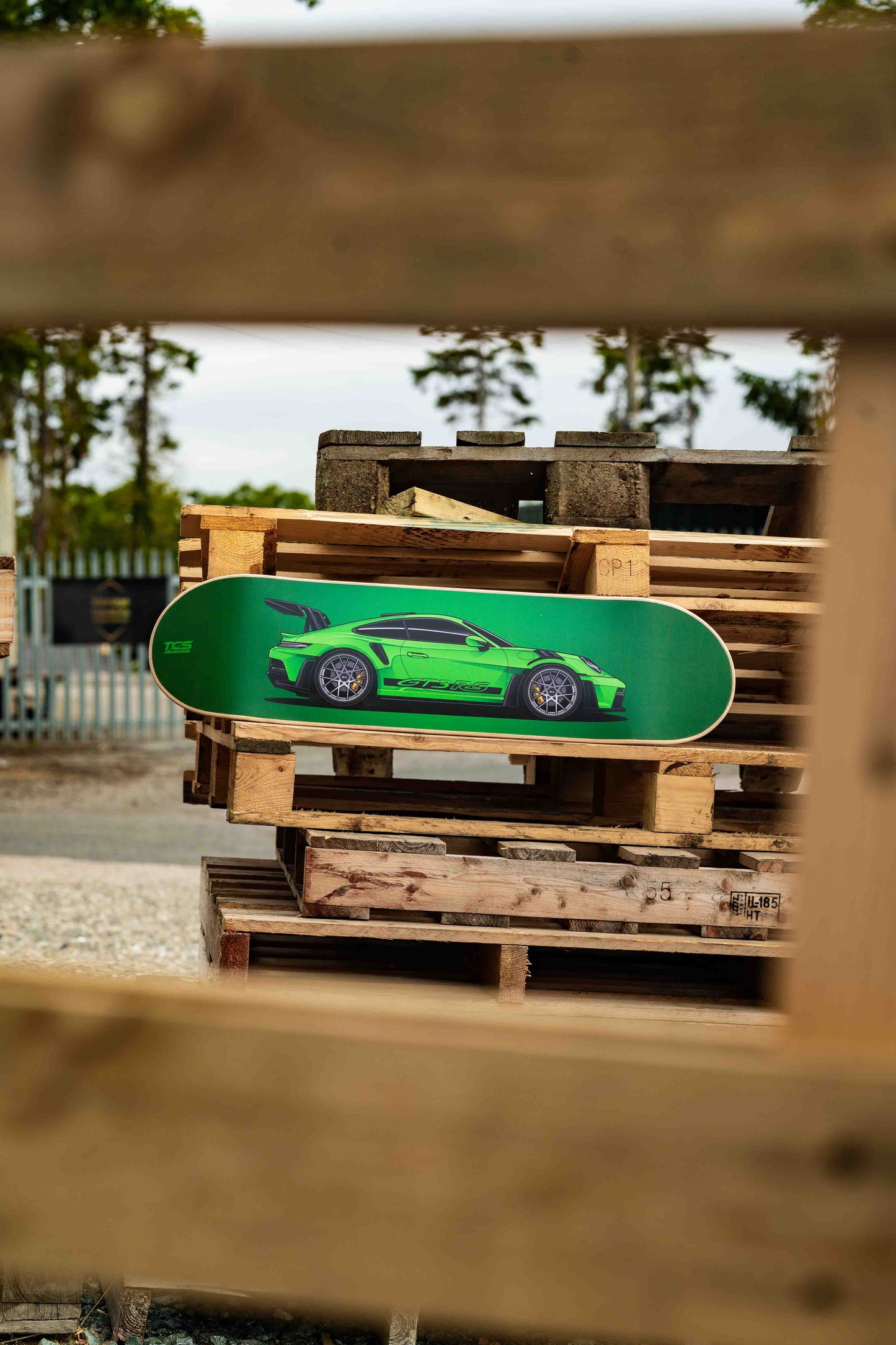 Green skateboard with a car design on wooden pallets