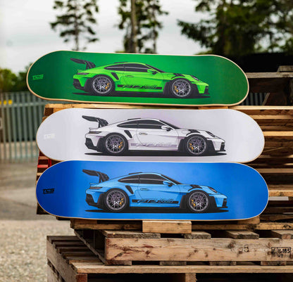 Three skateboard decks with GT3 RS designs stacked on a wooden pallet.