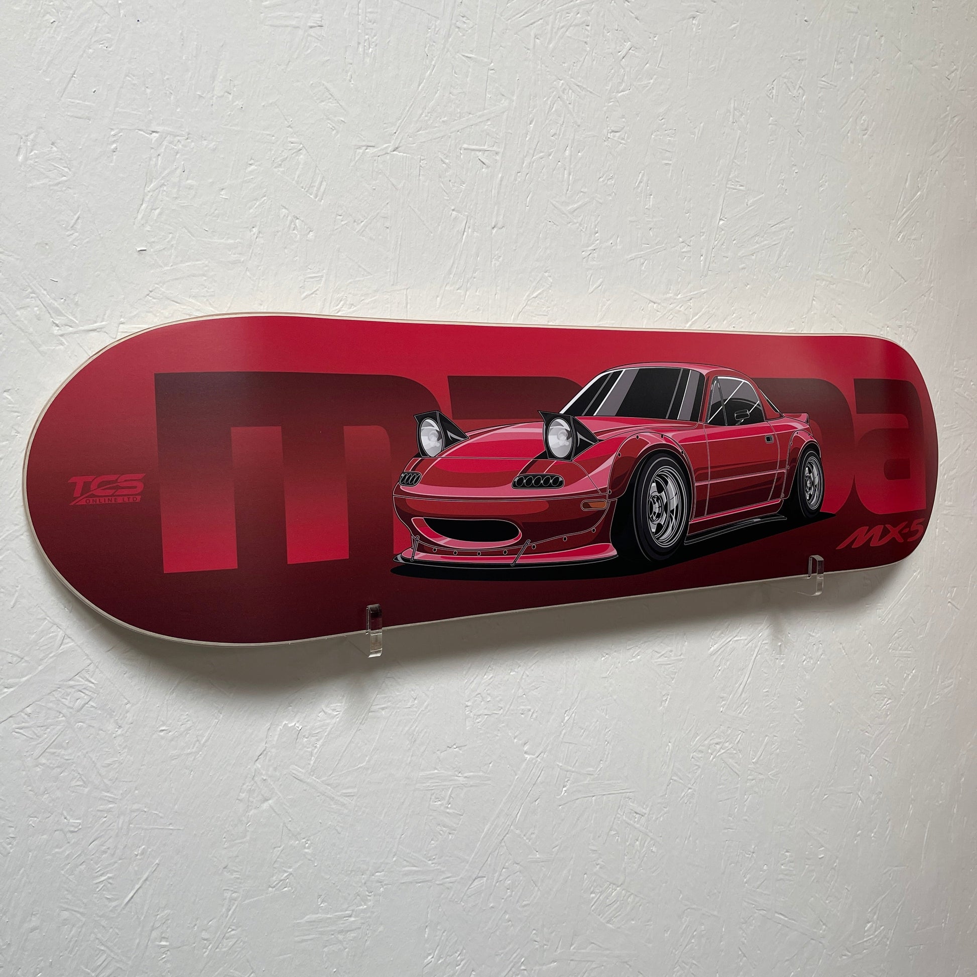 Red skateboard deck with a car design on a white background