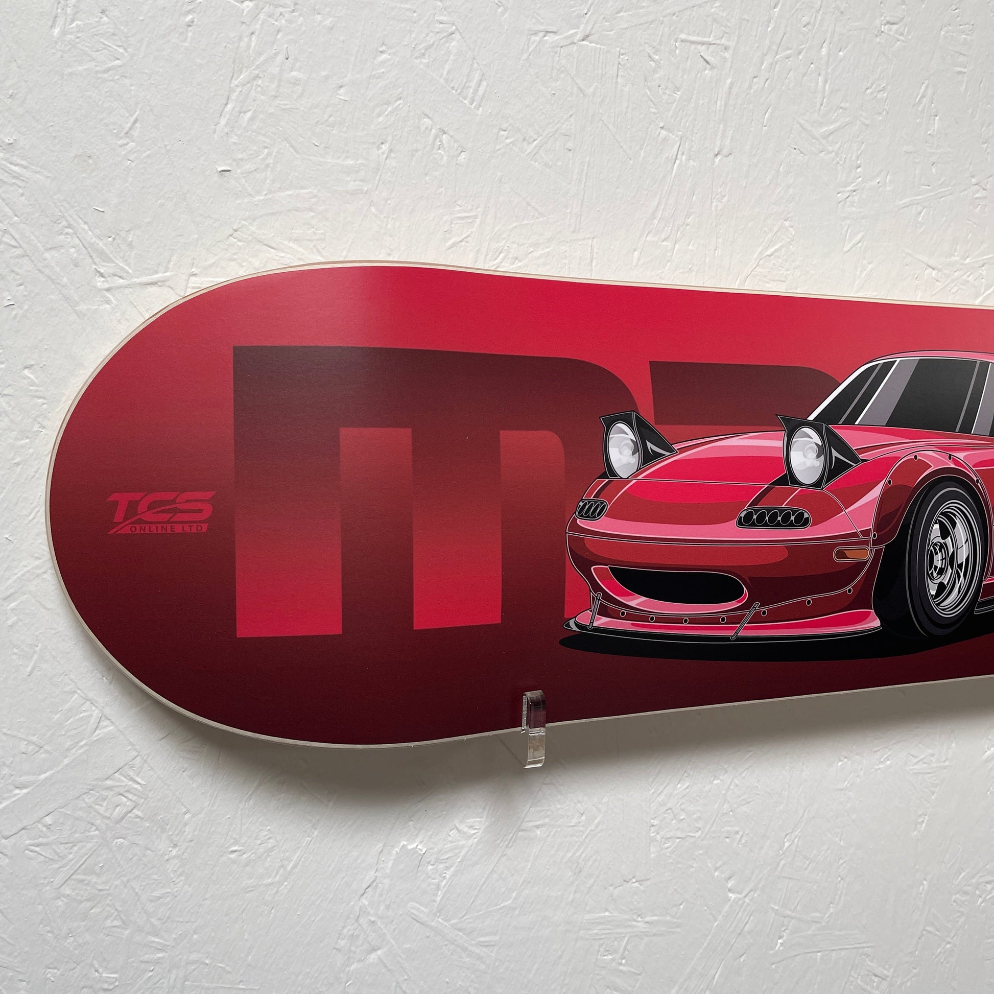 Red skateboard deck with a car design on a white background