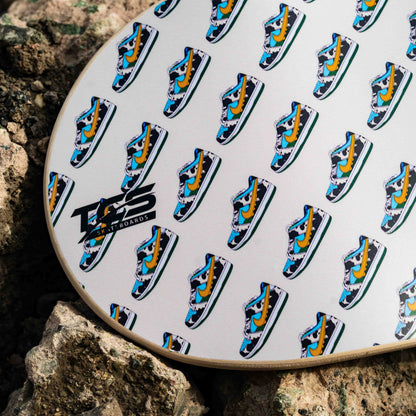 Patterned skateboard on a rock with visible branding