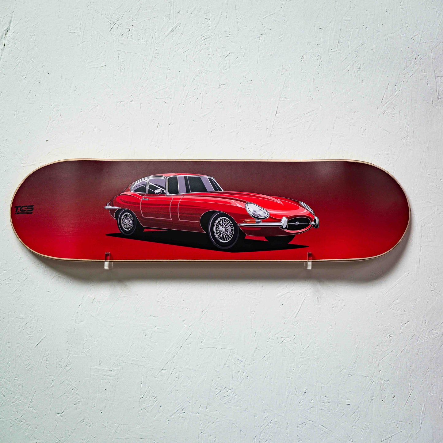 Skateboard deck with a red car design on a light gray background