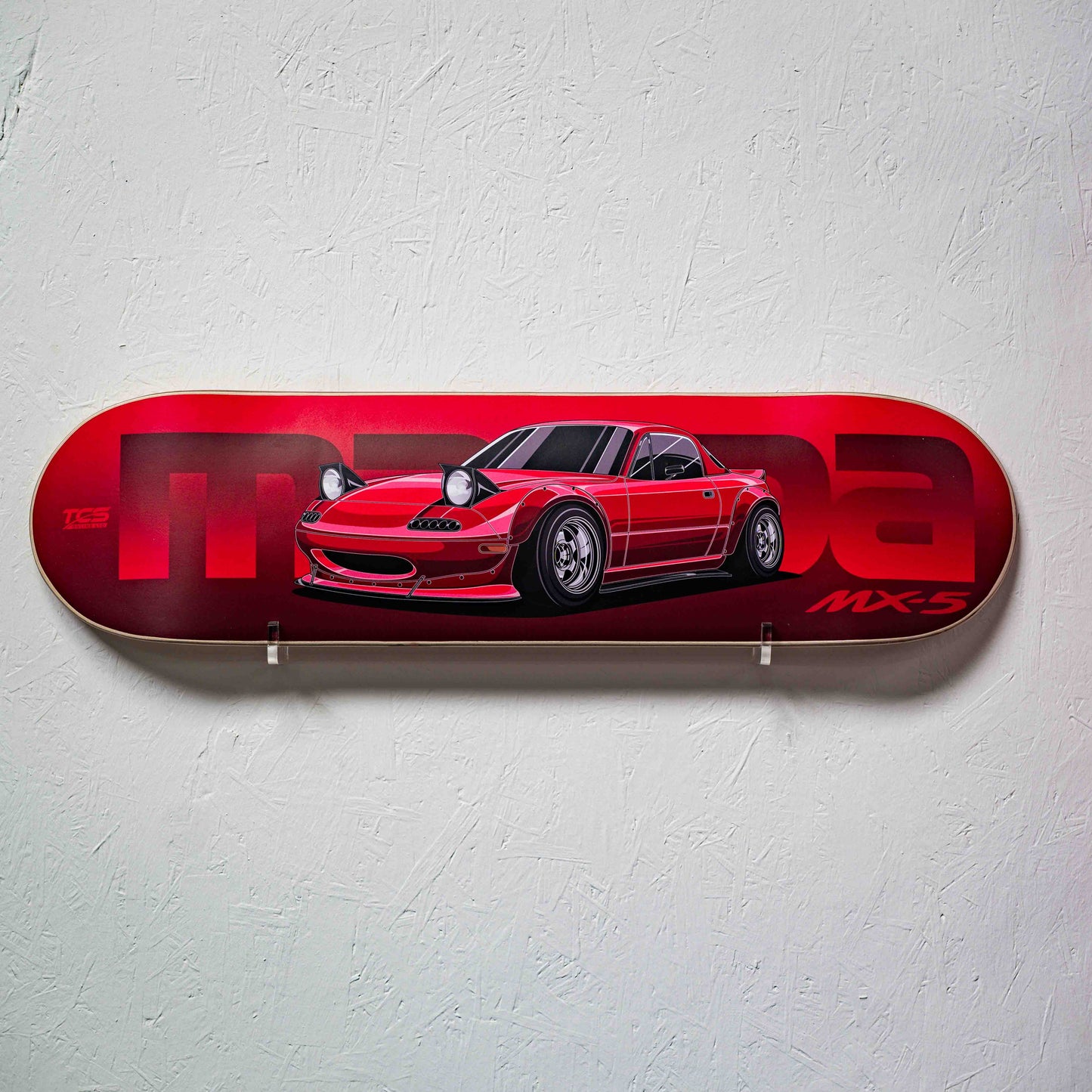 Red skateboard deck with a car design on a white wall