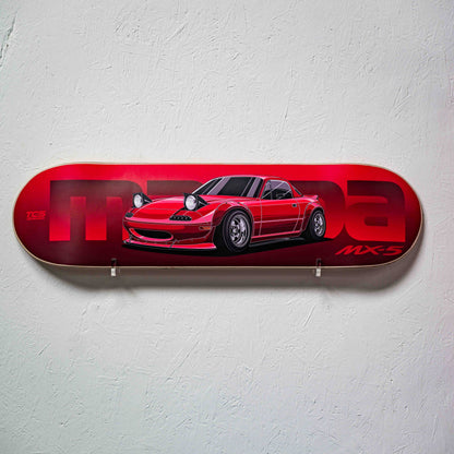 Red skateboard deck with a car design on a white wall