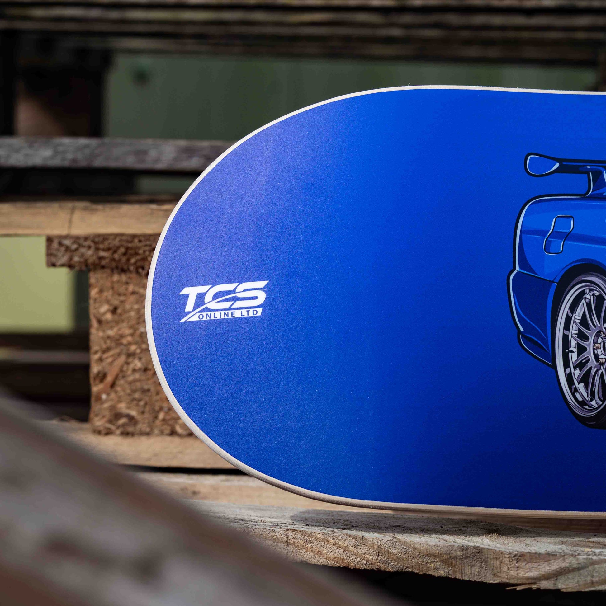 Blue skateboard deck with a logo on a wooden surface