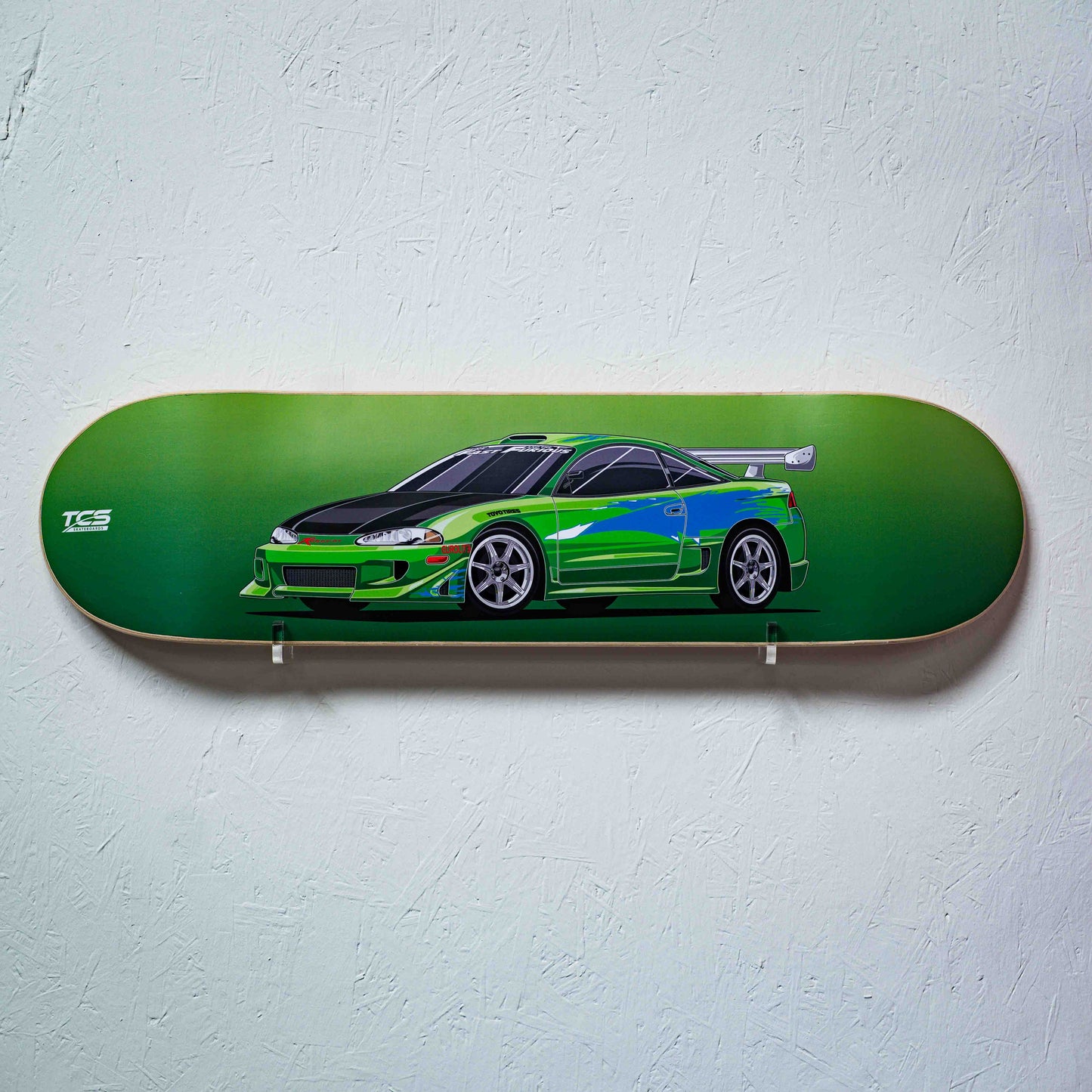 Skateboard deck with a green car design on a light gray background