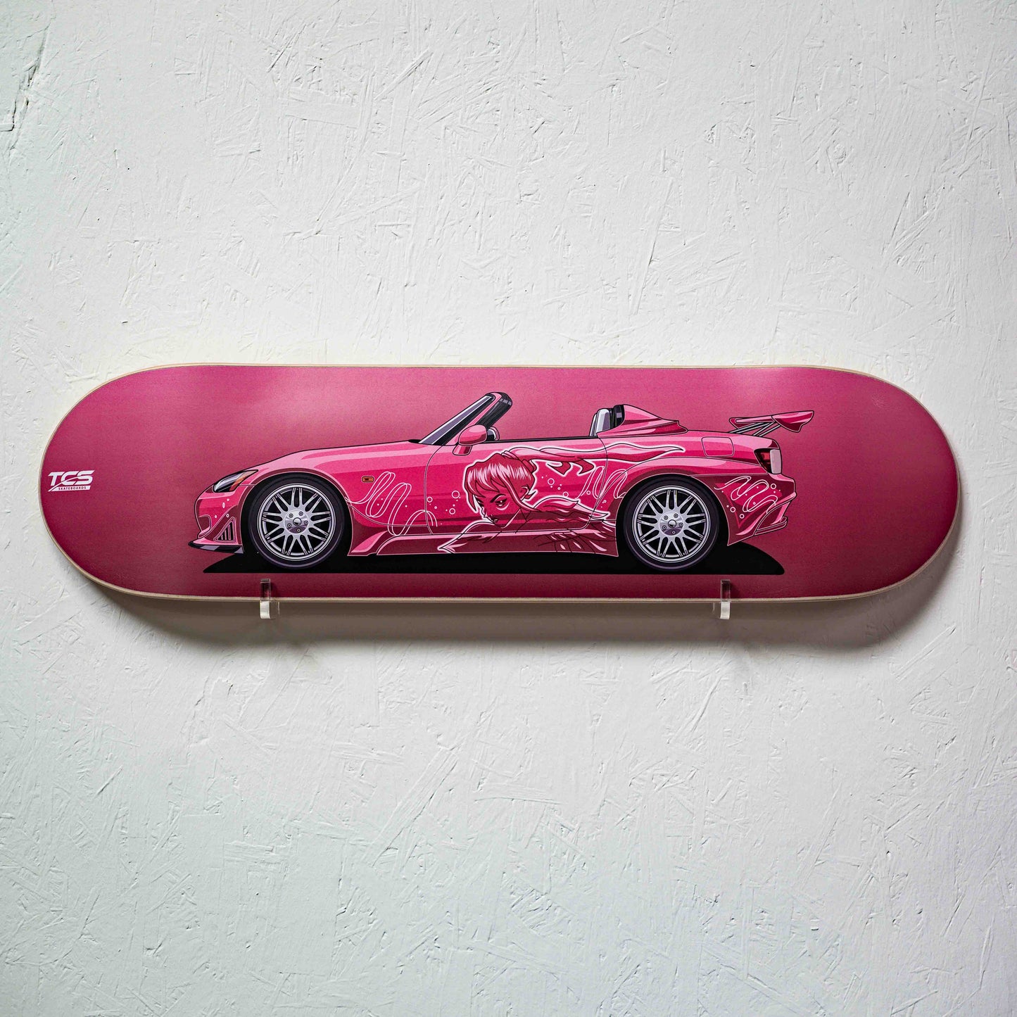 Skateboard deck with a pink car design on a white wall