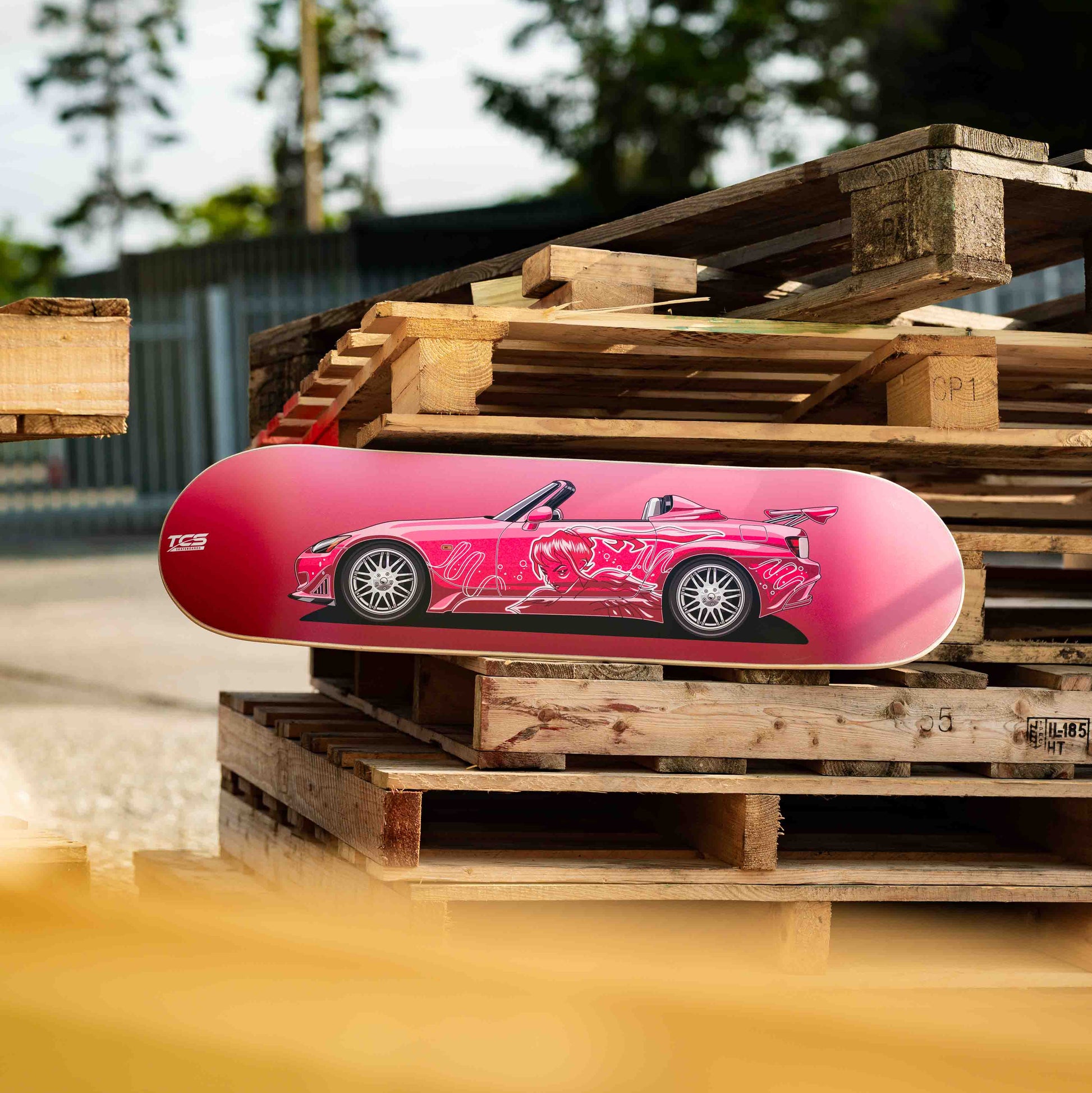 Pink car-shaped object on wooden pallets with blurred background