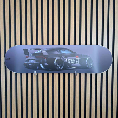 Skateboard deck with car design on a striped background