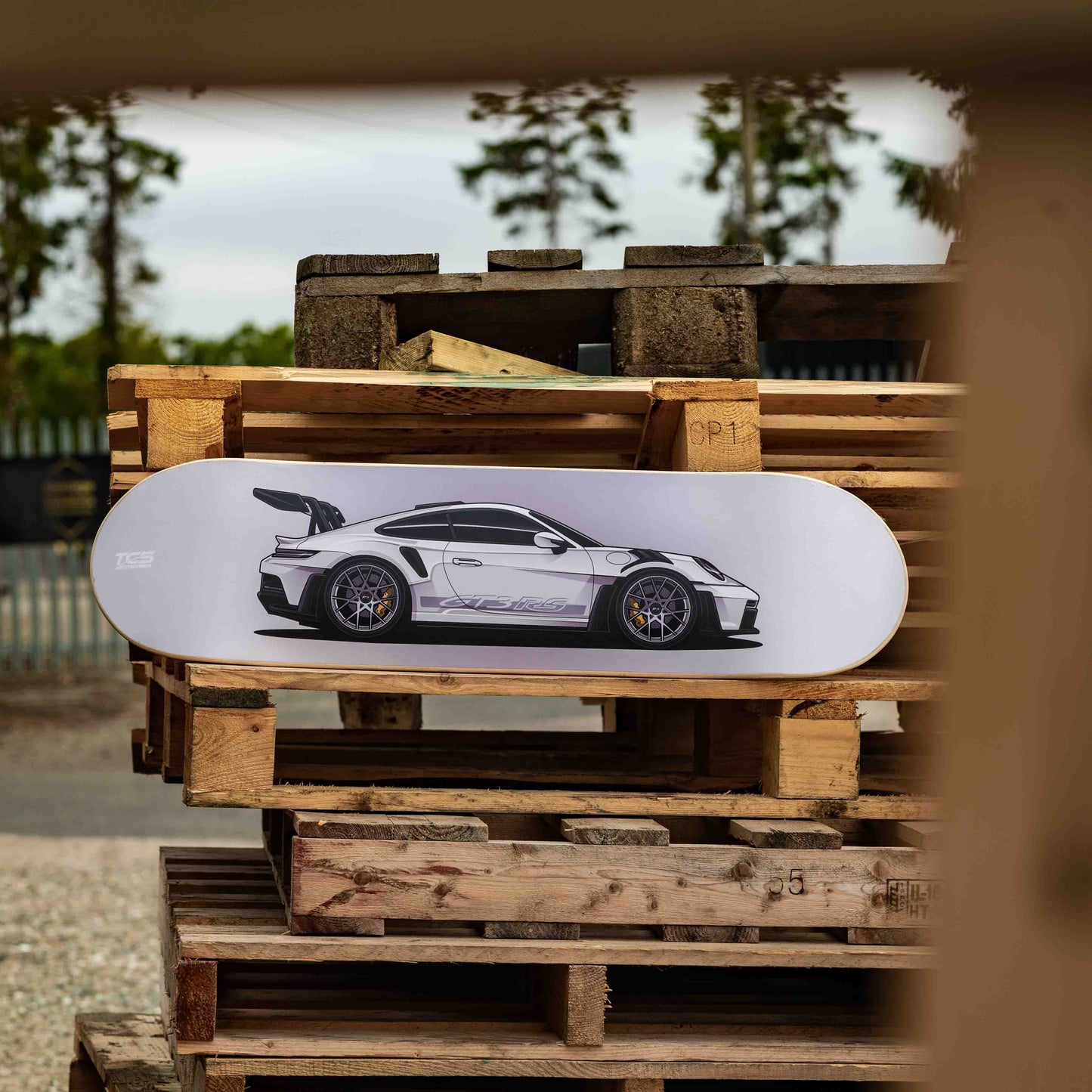 Skateboard with a car design on a wooden pallet outdoors