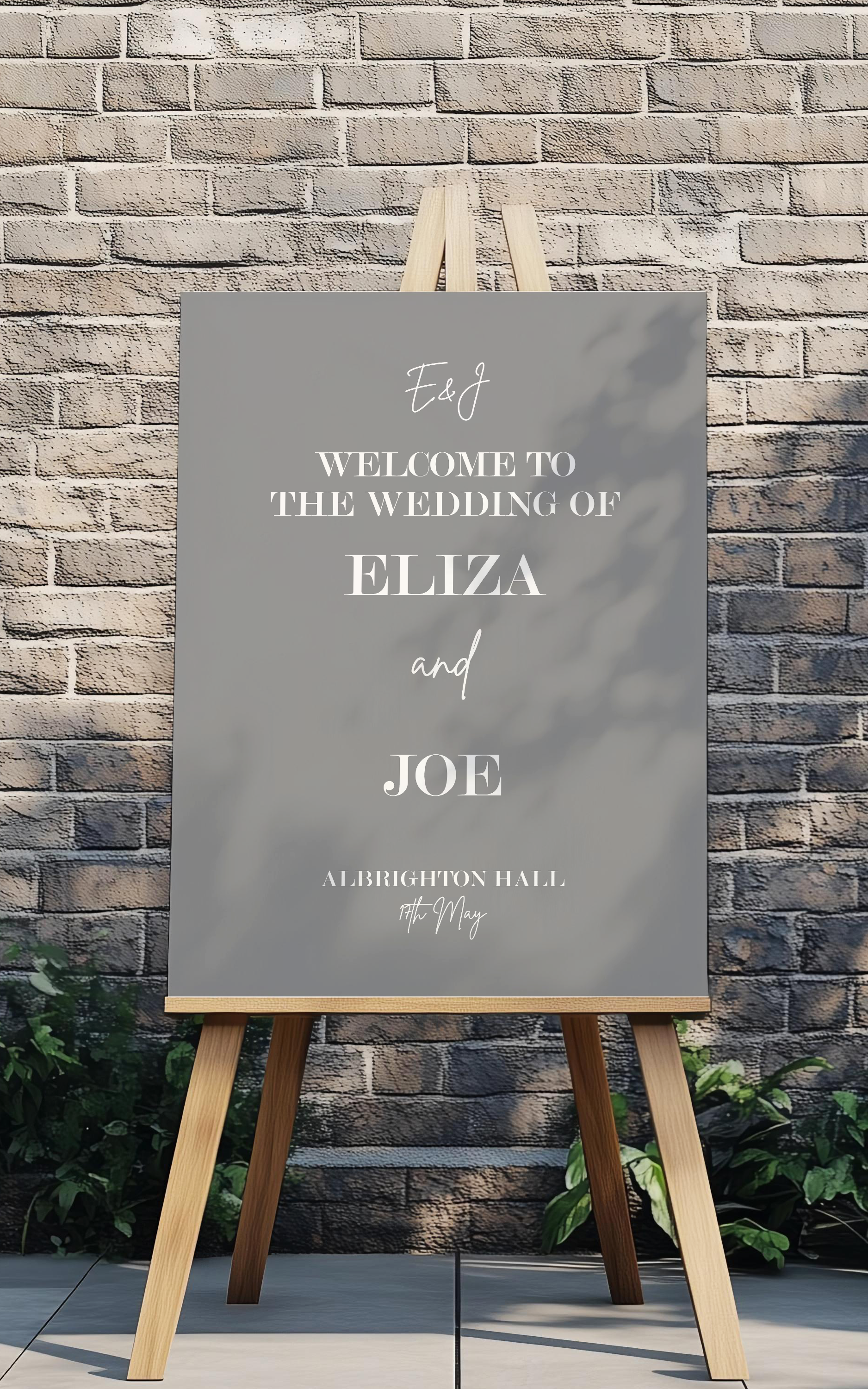 Wedding welcome sign on an easel against a brick wall